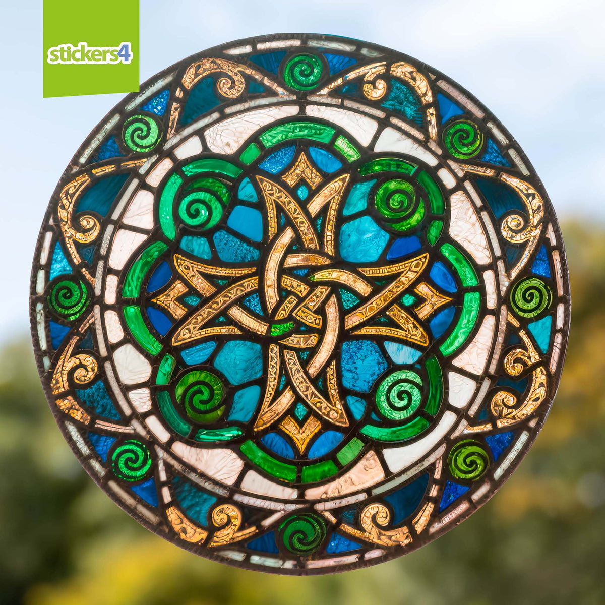 Decorative circular design with Celtic knot pattern in blue, green, and gold on a blurred natural background.