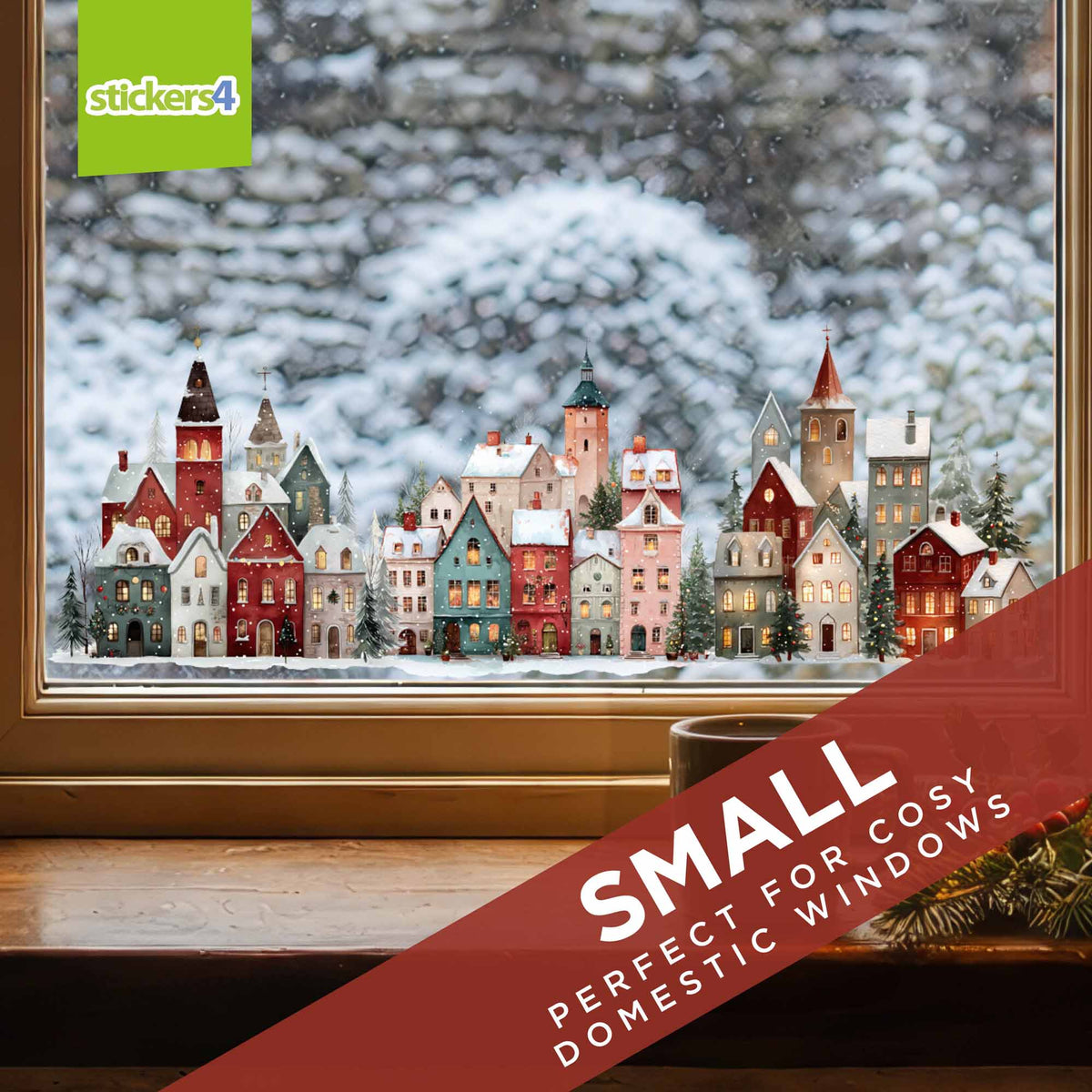 A decorative Christmas window sticker depicting a snowy village with colourful houses, shown applied to a window. 