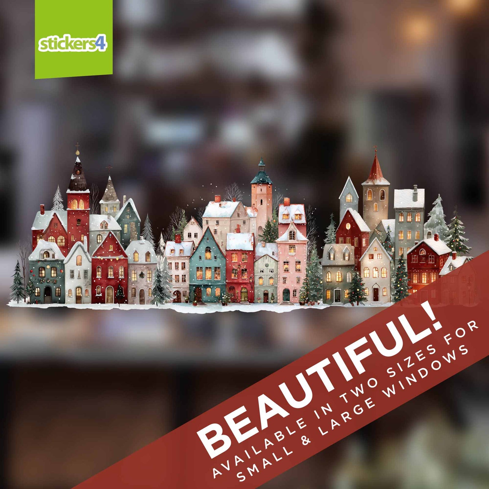 A decorative miniature village of colourful houses with snowy roofs and lit windows, shown as a product graphic with a blurred warm-toned background.  AVAILABLE IN TWO SIZES FOR SMALL & LARGE WINDOWS'.