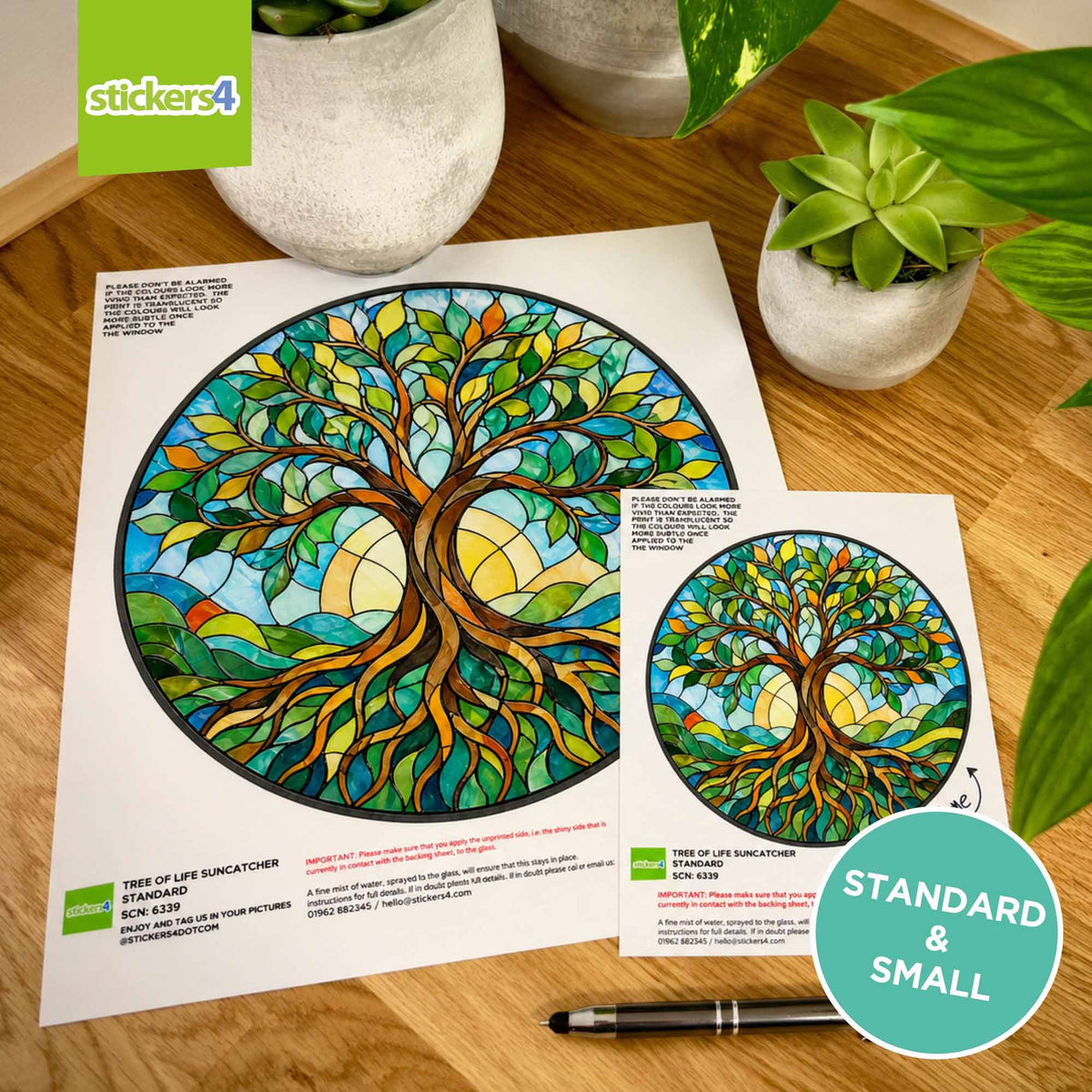 Stained glass tree of life designs on static cling with 'stickers4' branding, surrounded by potted plants.